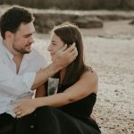 A couple enjoying a romantic moment on a beach in Colchester, England. Ideal for lifestyle and travel themes.