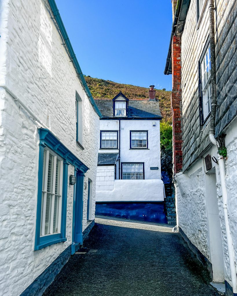 Picturesque alleyway lined with historic white cottages in Port Isaac, England